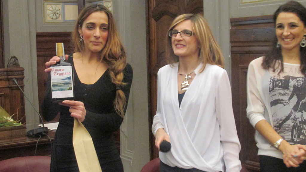 Vincenza Tropiano mostra l'Amaro Teggiano durante la premiazione 